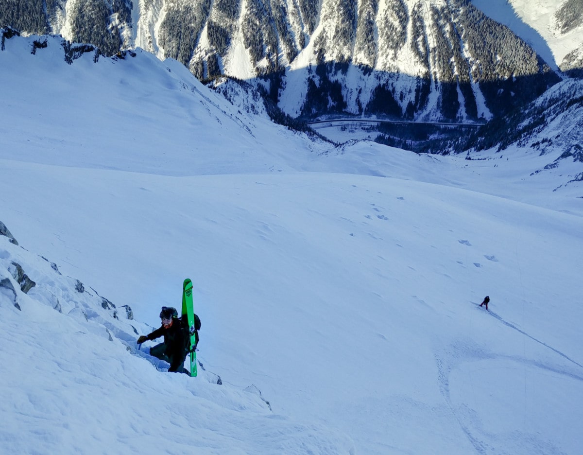 skier down climbing cliff face