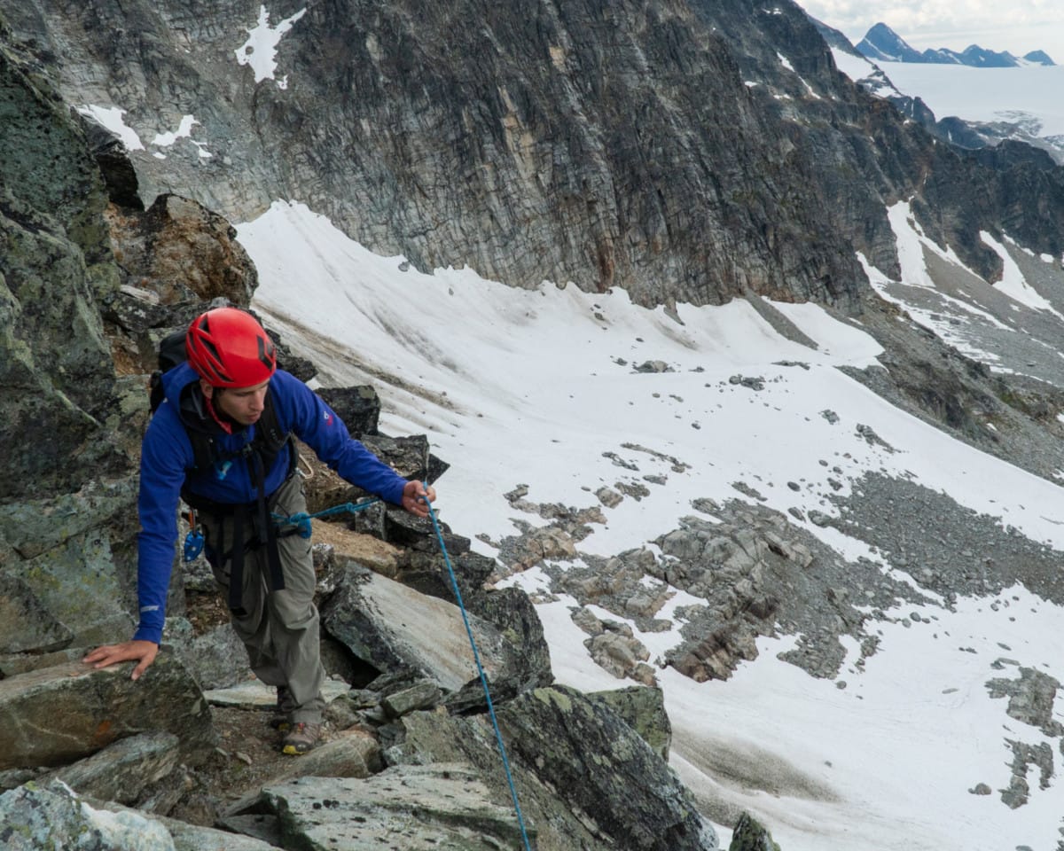 mountaineer untangling rope on avalanche mountain