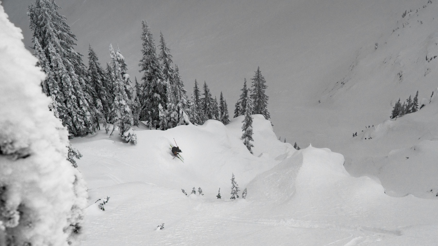 backcountry skier slashing a big turn past a cleaver