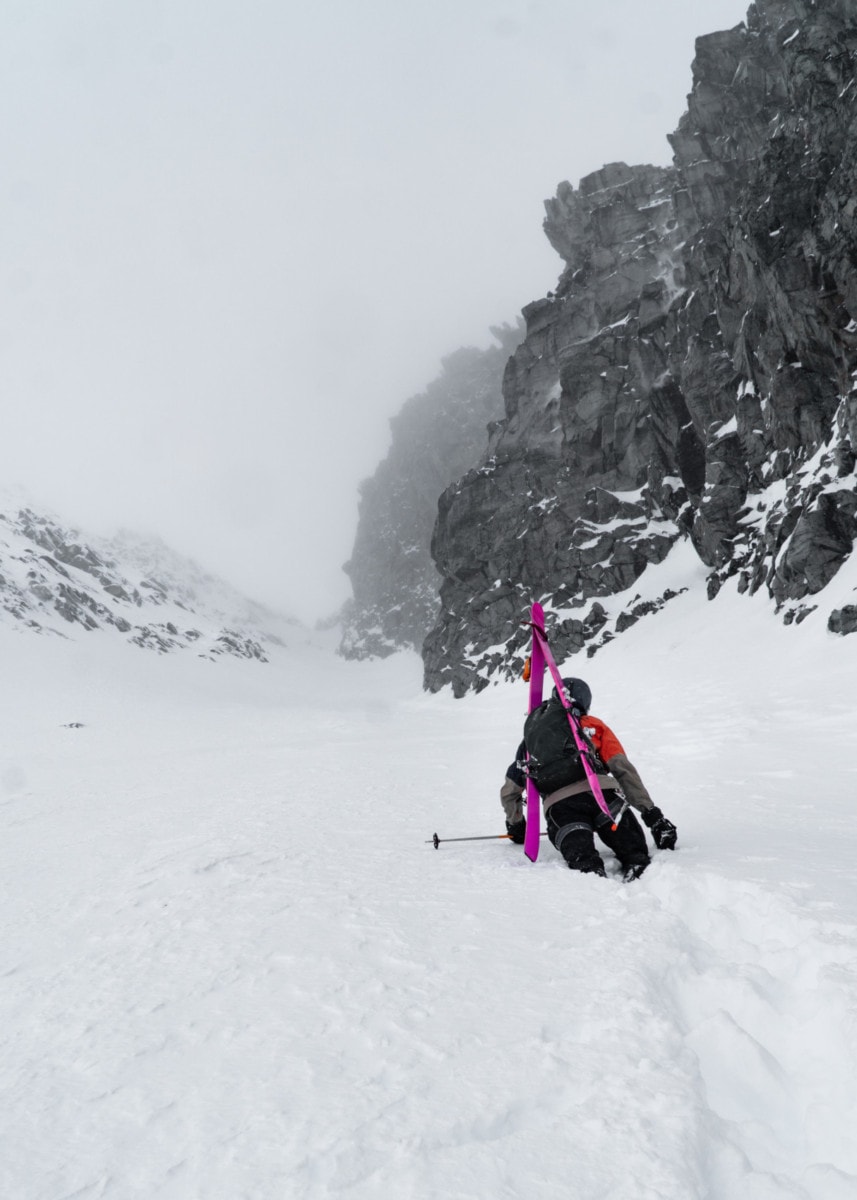 skier booting up swiss couloir