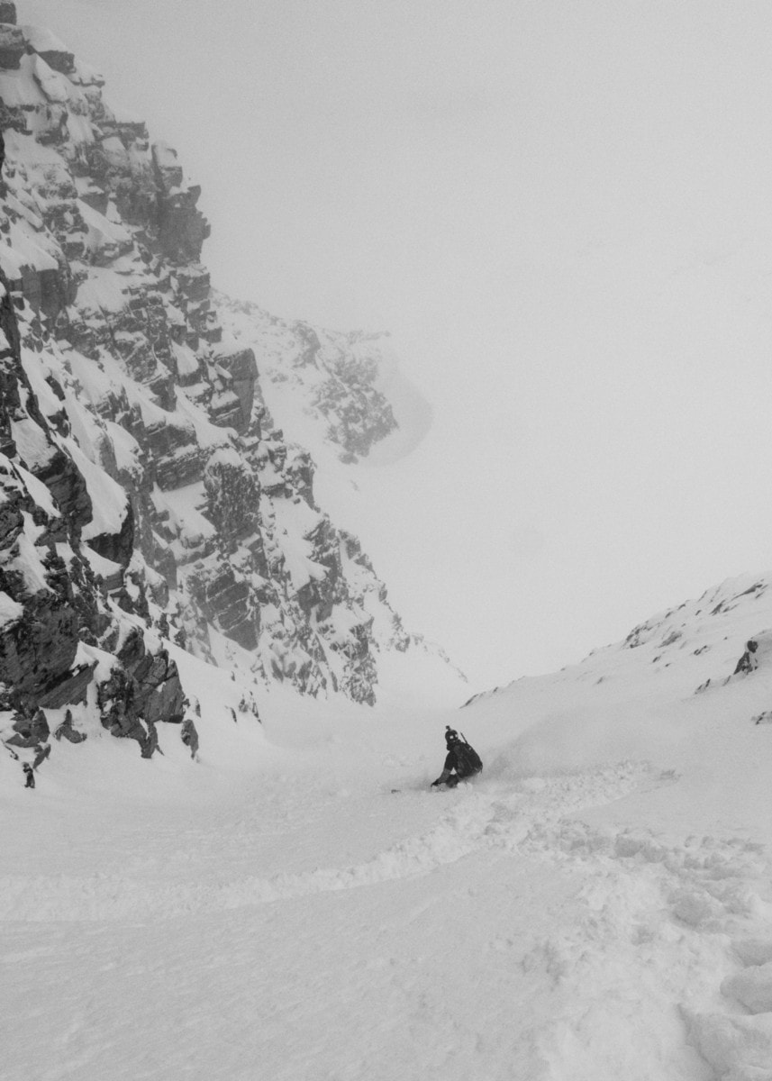 skier slashing a turn down swiss couloir