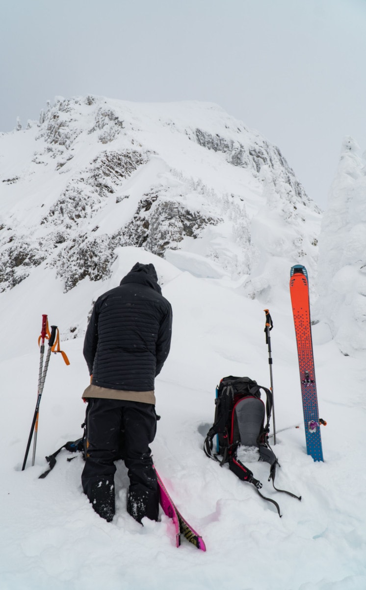ski tourer sorting his gear on the east ridge of ghost peak