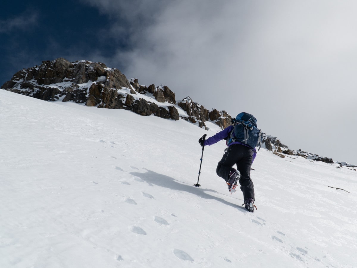 woman agressively cramponing up the west slope of mt daly