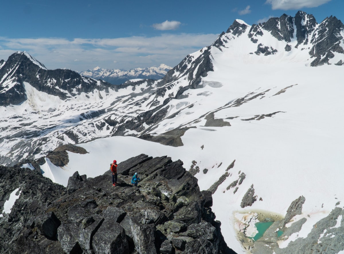 two climbers taking a break on a rocky bench along the west ridge of mt tupper