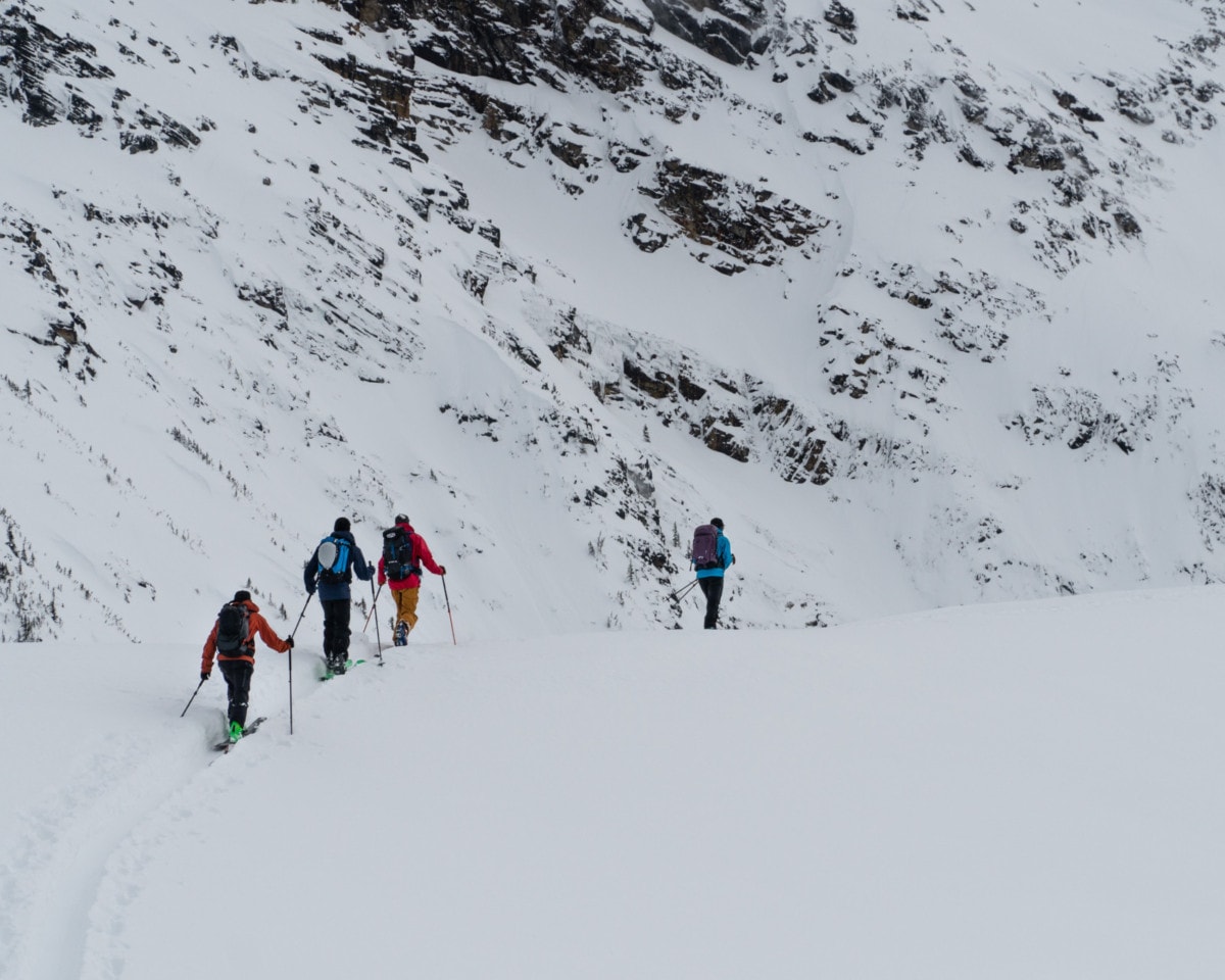 close up on a group of ski tourer with large mountains in the back
