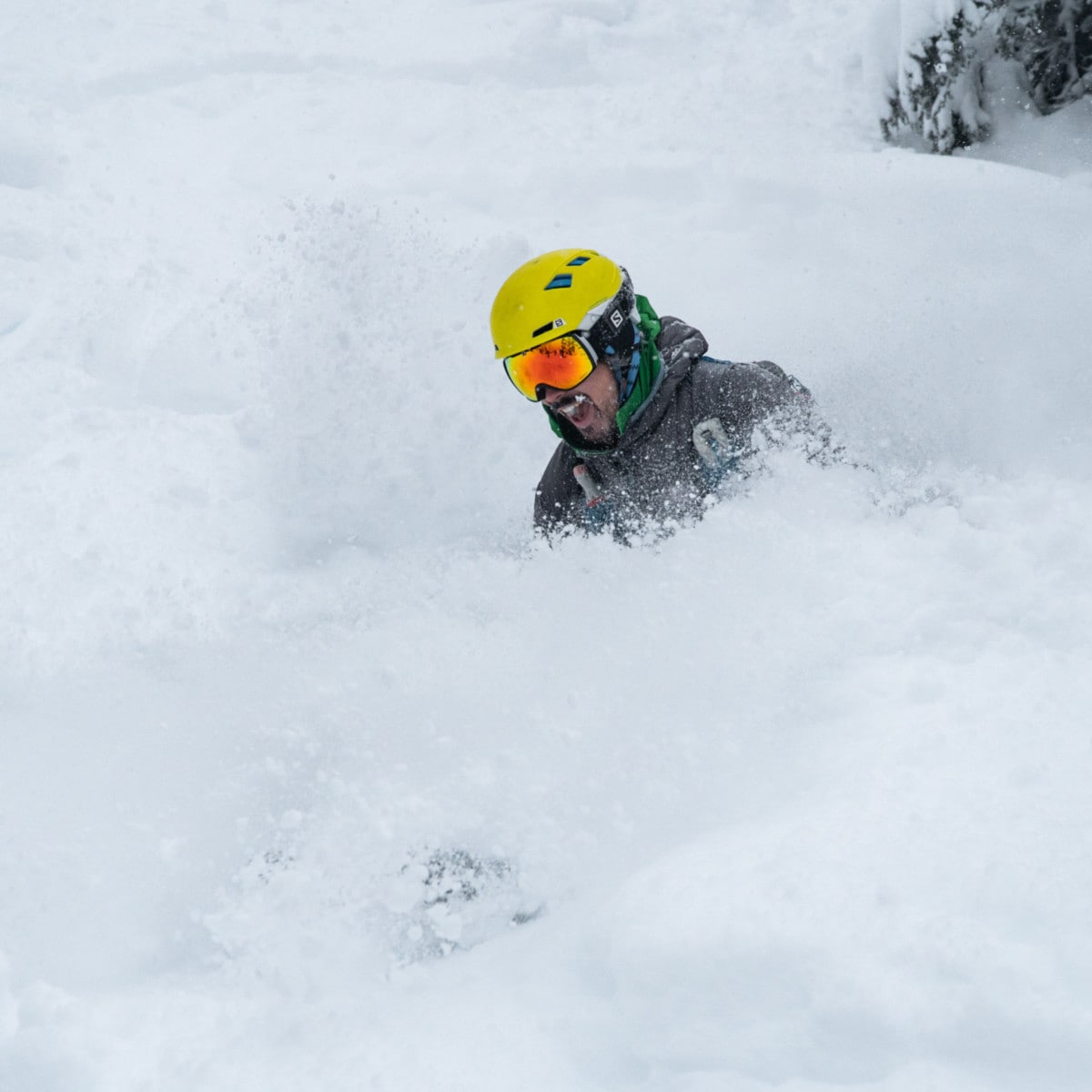 skier buried under snow as he makes a turn