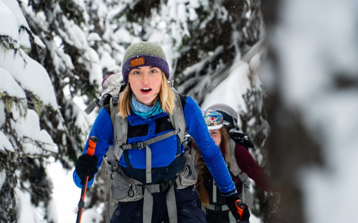 woman walking up the grizzly shoulder on skis