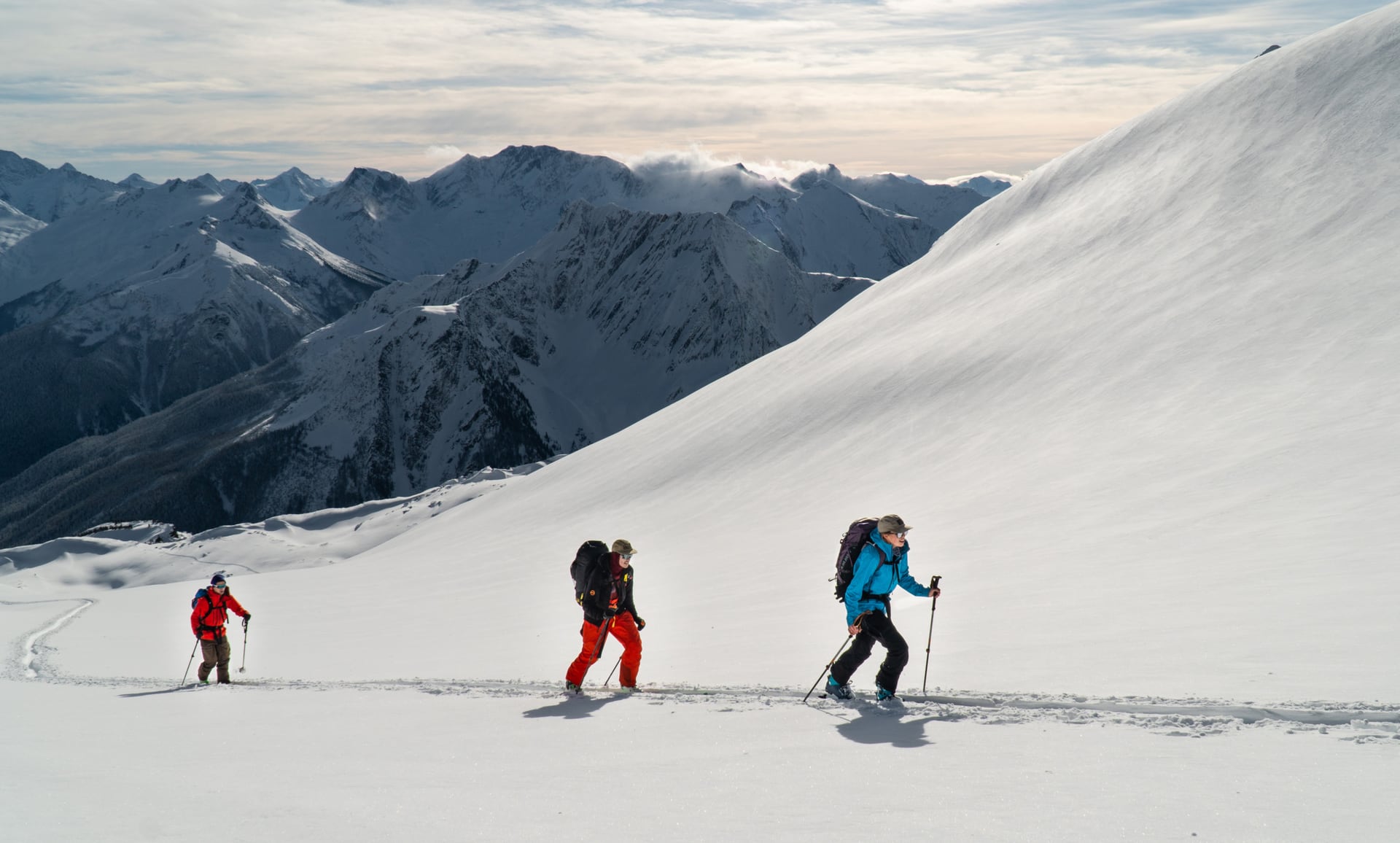 skiers ascending a snowy slope in rogers pass featured