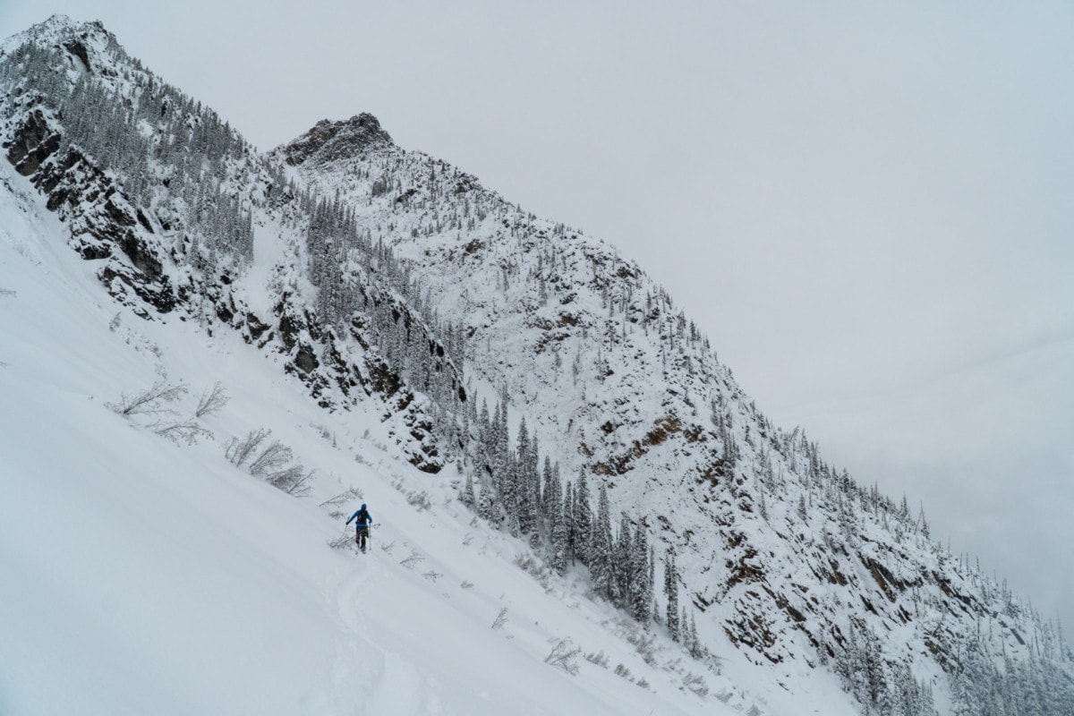 solo splitboarder traversing below ross peak in rogers pass