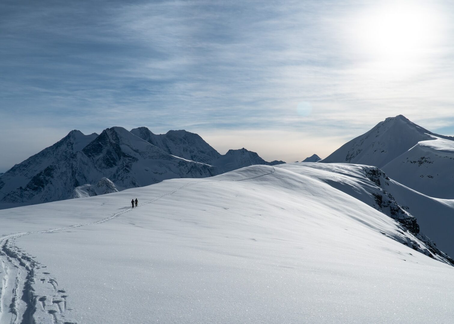 two skiers traversing the illecillewaet glacier on their way to forever young couloir