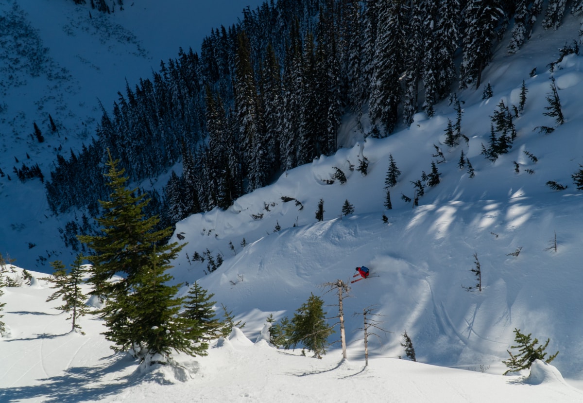 skier slashing a quick turn down a treed gully