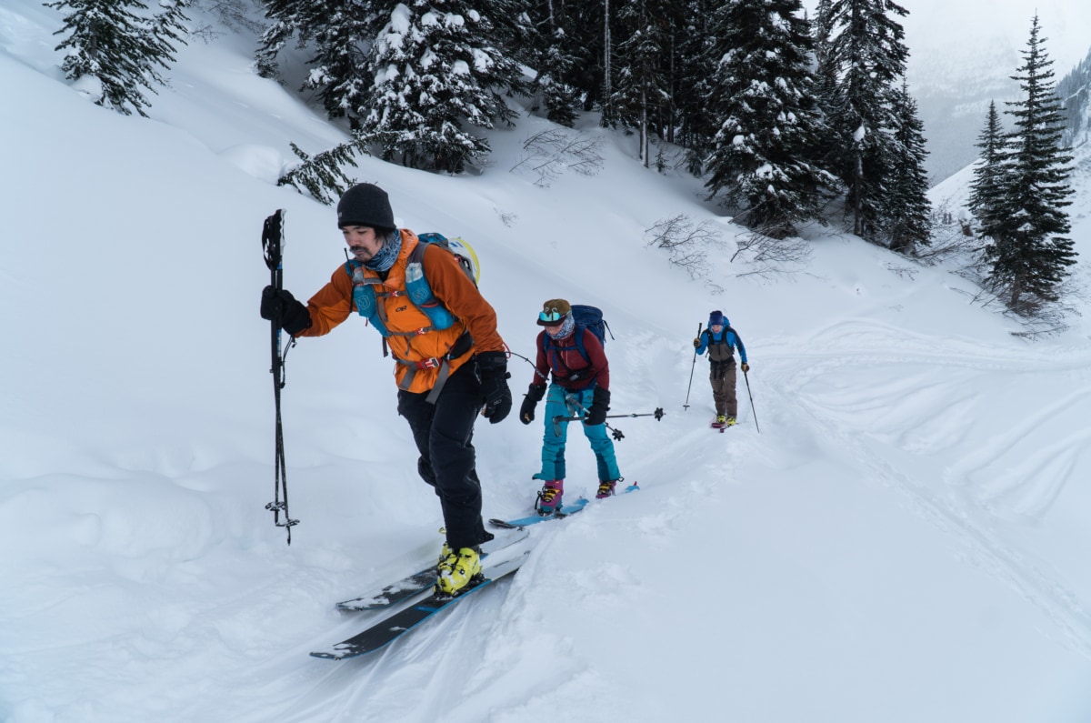 three ski tourers touring up the hospital bowl uptrack