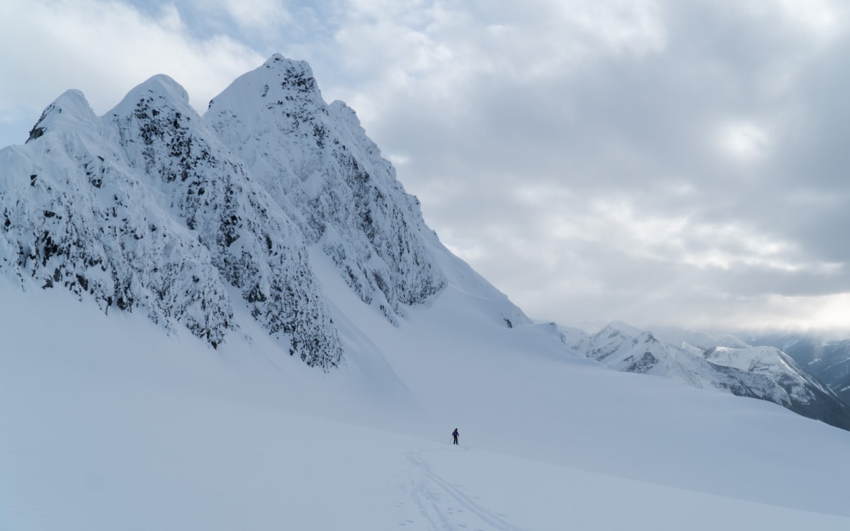 man skiing on the avalanche north glacier with avalanche mt in the distance