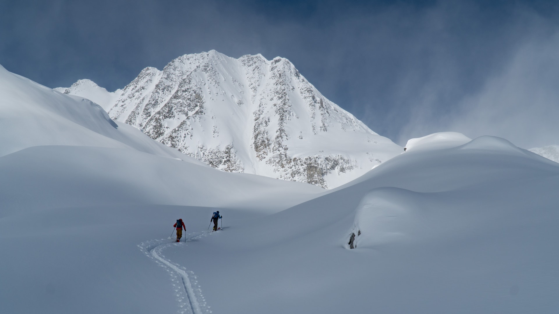 two ski tourers walking towards the sifton glacier mt sifton south face in the back