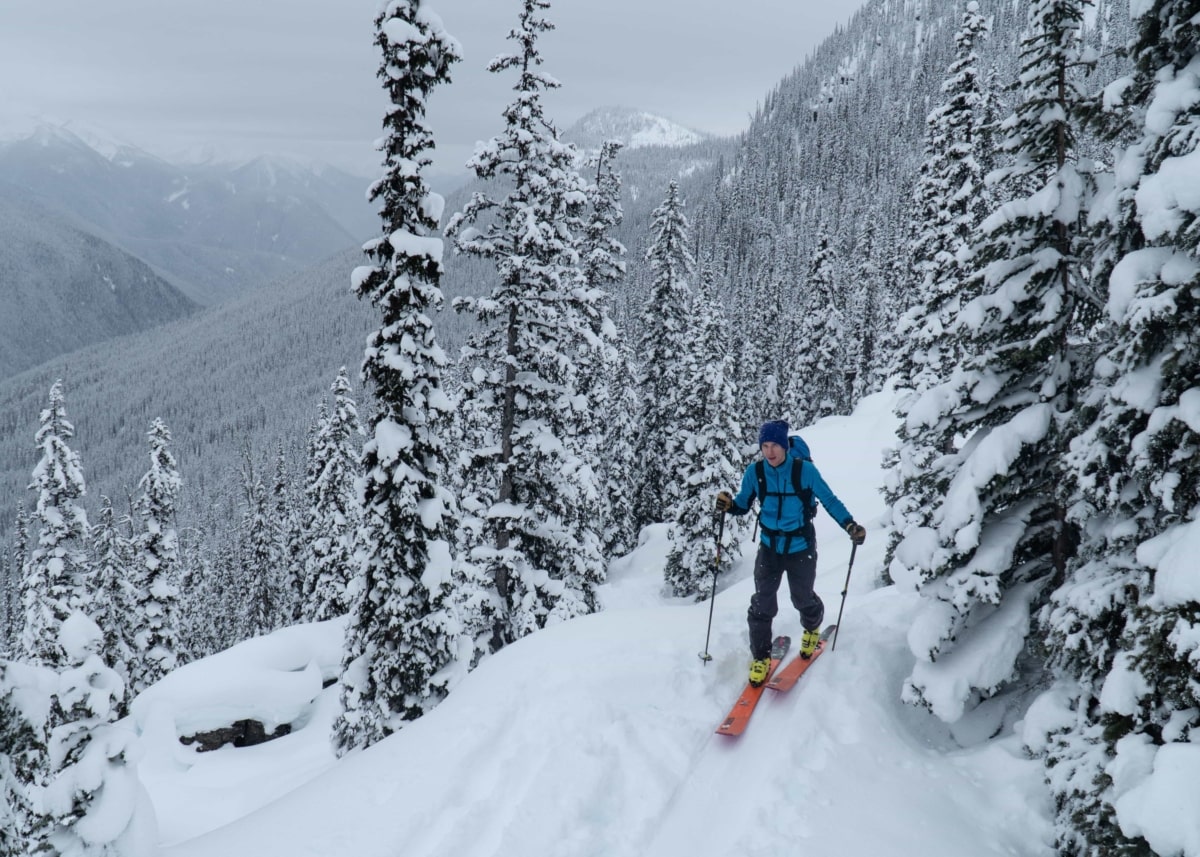 man happily ski touring up corbin pass min