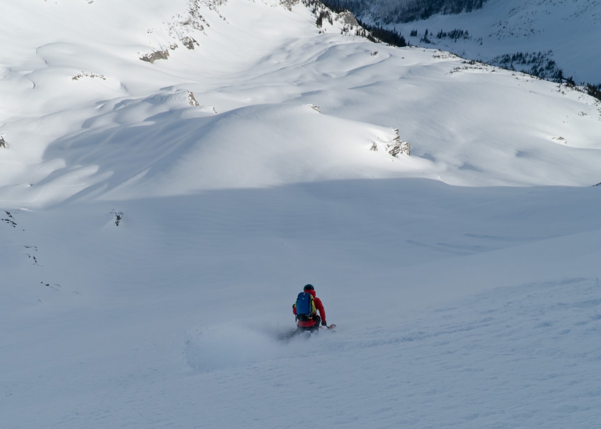 freddy slashing a big turn on skis down the east face of catamount peak