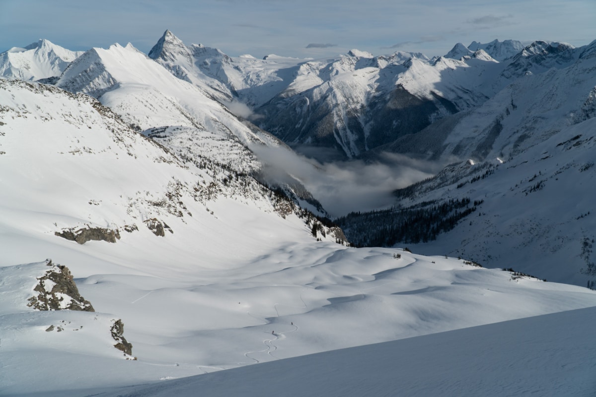 two skiers carving tracks down catamount east face