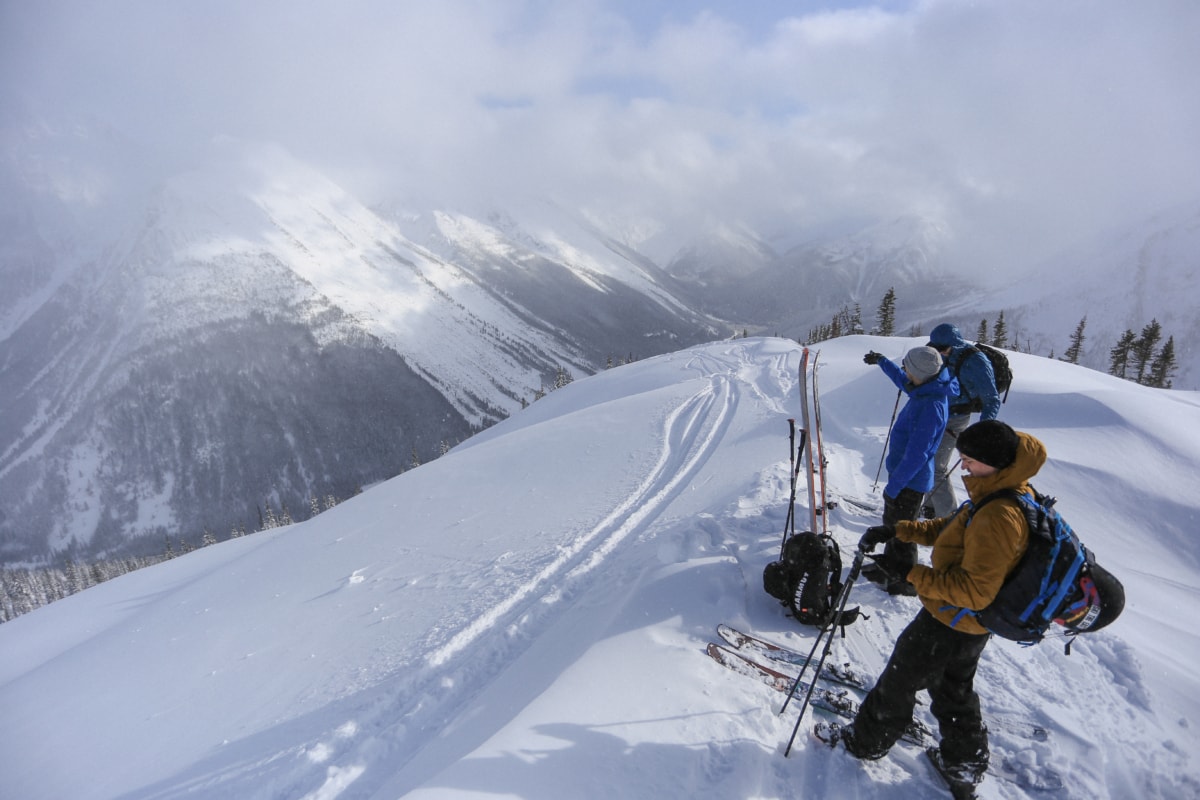 man pointing in the distance at a ski line int he winter