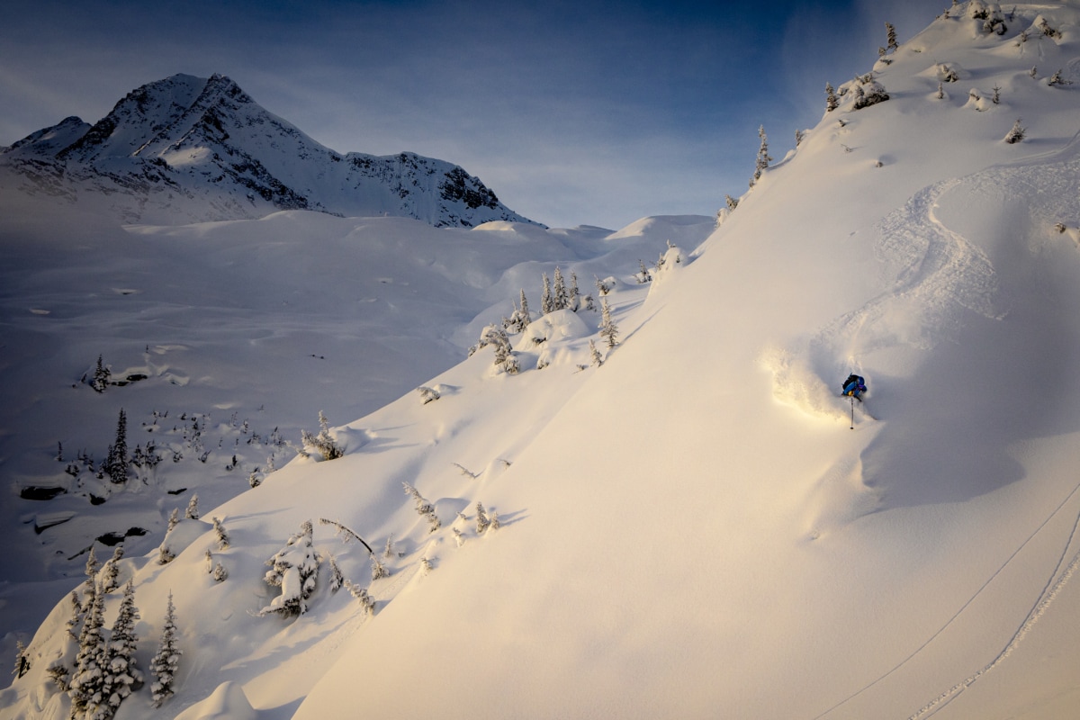 man skiing down a snowy slope near the swiss glacier