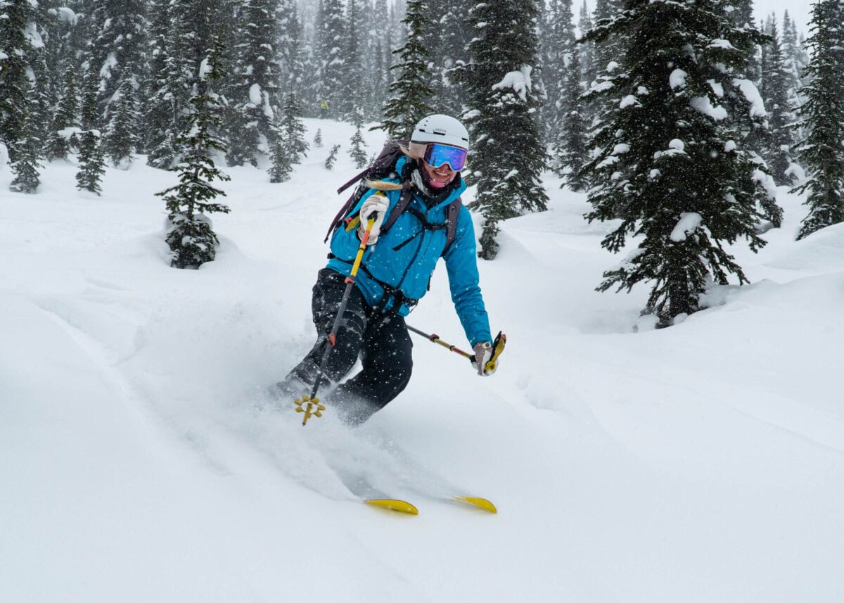 skier slashing a turn in deep powder