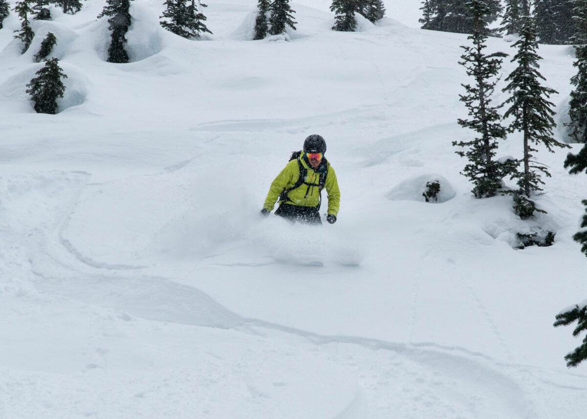 skier slashing in deep powder on wolverine ridge