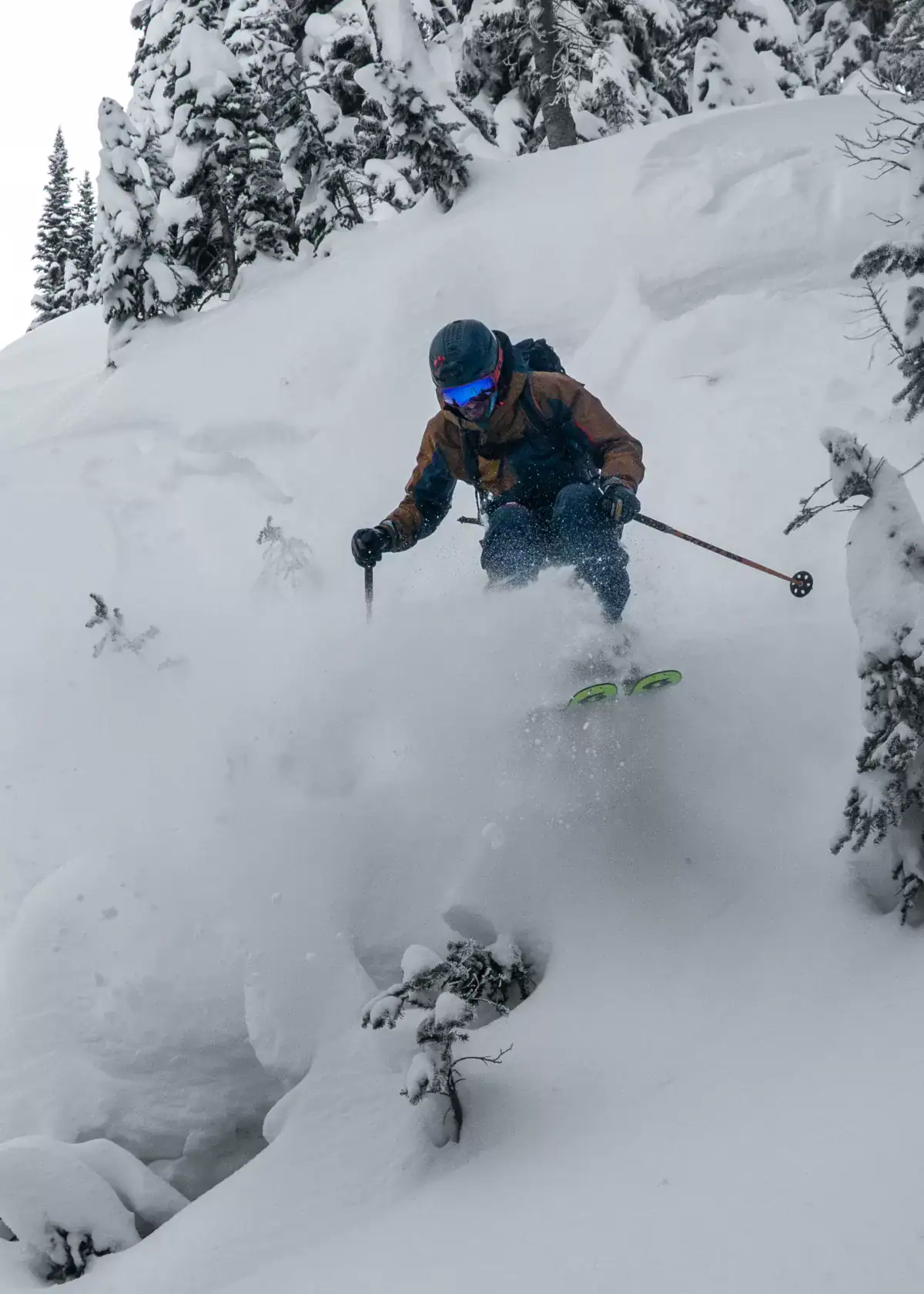 skier jumping off a pillow in deep powder