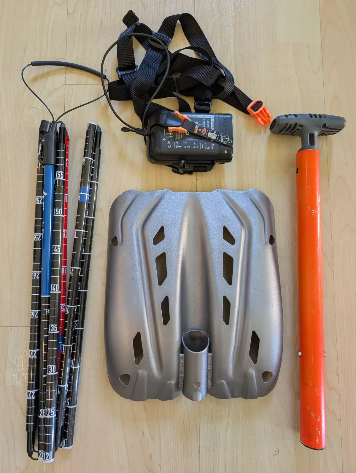 overhead shot of the avalanche safety gear including transceiver, shovel and probe
