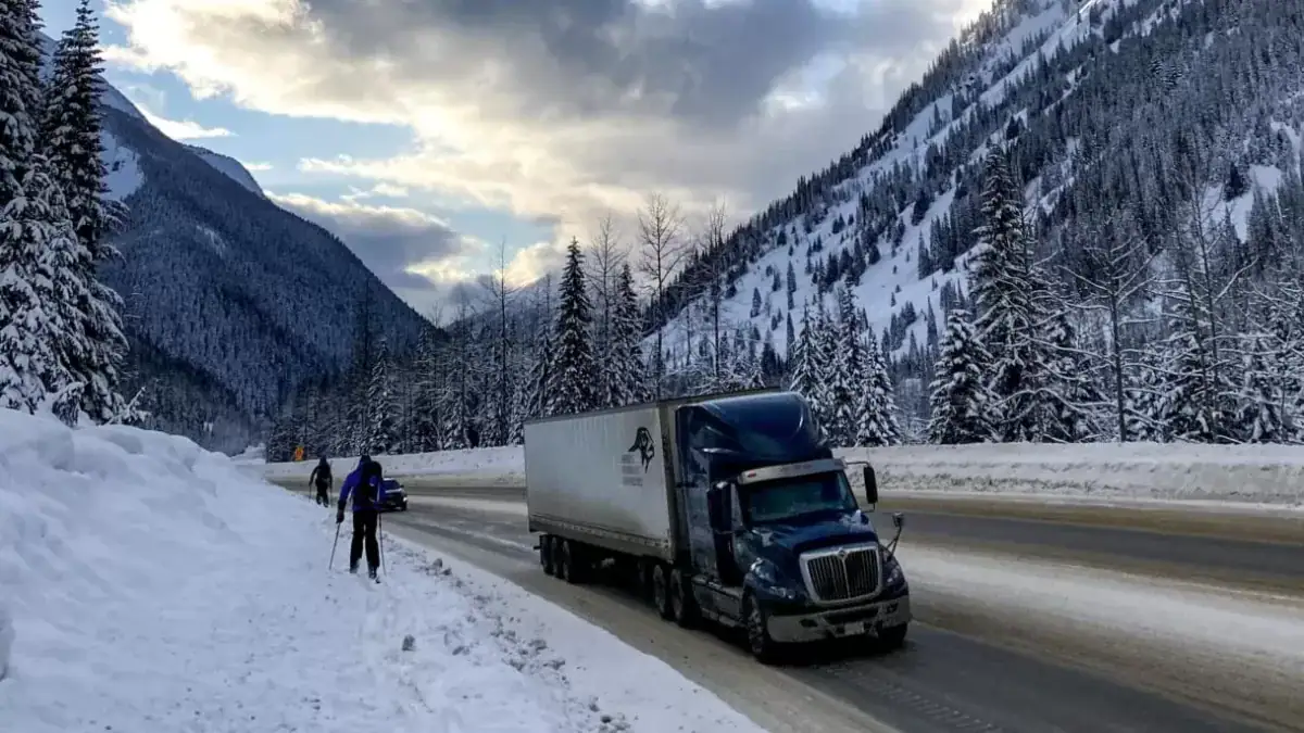 person ski touring next to the highway