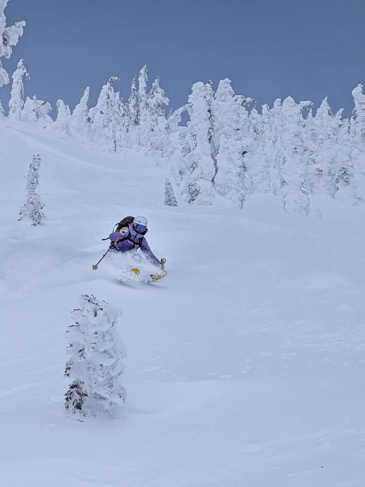 female skier slashing a powdery pillow