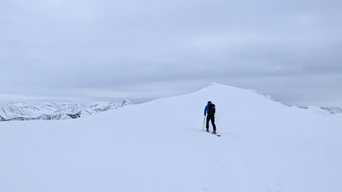 skier gliding across the top of montana peak in the rmr slackcountry