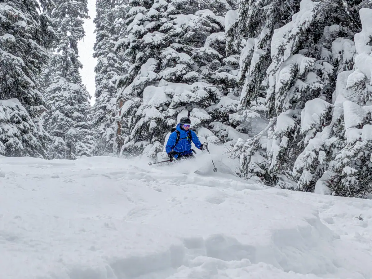 skier slashing a turn in deep powder