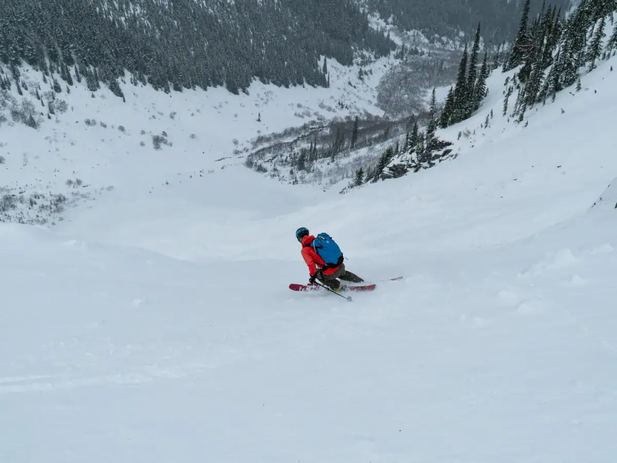 skier slashing a turn in thin powder at rogers pass
